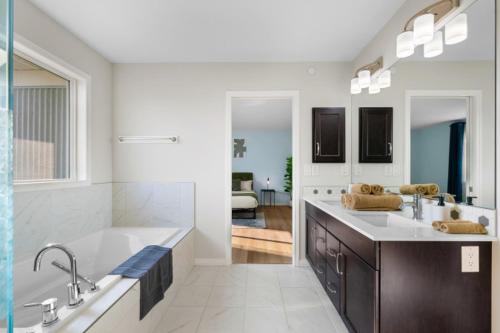 a large bathroom with two sinks and a tub at Spacious 5BR, Hot Tub and Pool Table - Sleeps 16 in YYC