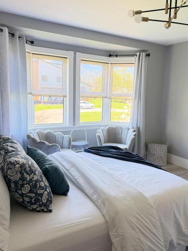 a large white bed in a room with windows at luxury Beachfront Home With Private Beach Access in Charlottetown
