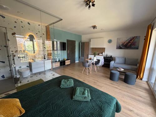 a large living room with a bed and a living room at Flauta Apartamenty in Augustów