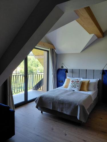 a bedroom with a bed and a large window at Apartamenty Etno Pieniny in Jaworki