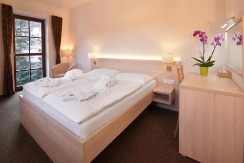 a bedroom with a large white bed in a room at Wellness hotel Sauna in Malá Morávka