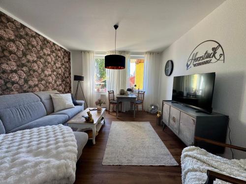 a living room with a blue couch and a tv at Herzstück in Schwanebeck