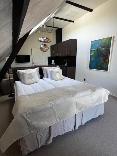 a bedroom with a large bed with white sheets and pillows at Ludvigsdals Gård in Ystad