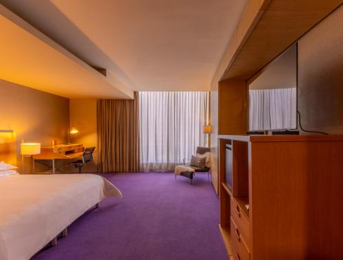 a hotel room with a bed and a flat screen tv at Barceló México Santa Fe in Mexico City