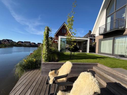 two sheep sitting on a bench next to a house at Waterfront in Alkmaar