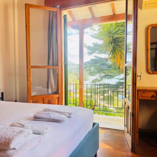 a bedroom with a bed and a balcony with a view at Christina's Sea View House in Yénion