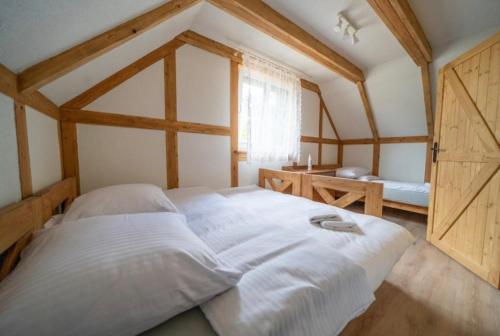 a large white bed in a room with a window at Domek Na Gwizdówce nr52 in Załakowo