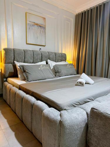 a large bed in a room with a couch at Grand Studio Cosy in Cocody
