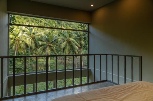 a bedroom with a bed and a large window at Elegant and Stylish - Riverside Tiny House Apartment in El Valle