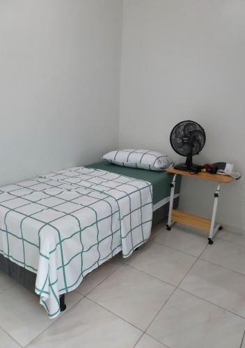 a bedroom with a bed and a desk with a fan at Seis Quarto Hospedaria - Suíte Com Ar ou Ventilador - Self Checkin - Centro in Juazeiro do Norte