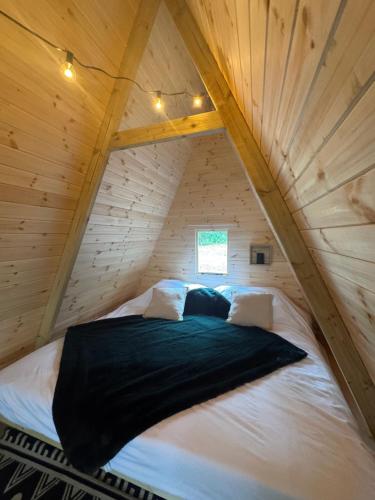 a bed in the attic of a log cabin at Little Brook Glamping in Salfords