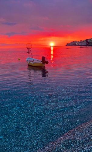 a boat in the water with a sunset in the background at Dimora di Diamante in Diamante