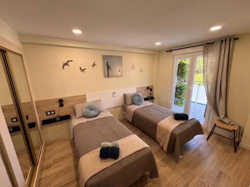 a bedroom with two beds and a window at Apartamento a 3 min de la playa, 10 min PortAventura World - Casa Márquez TAC - Costa Dorada in Salou
