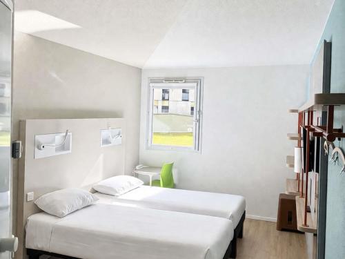 two beds in a small room with a window at Ibis budget Dijon Centre Clemenceau in Dijon
