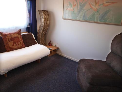 a living room with a couch and a chair at Mornington Motel in Mornington