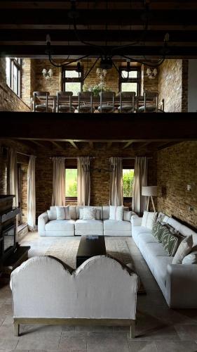 a living room with white couches in a brick wall at Casa de piedra en el valle a 20 minutos de Ribadeo y Playa de las Catedrales in Salcido