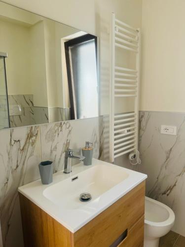 a bathroom with a sink and a mirror and a toilet at Villa Domini in Soverato Marina