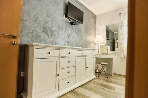 a white dresser with a television on a wall at House Mellifera in Razvođe