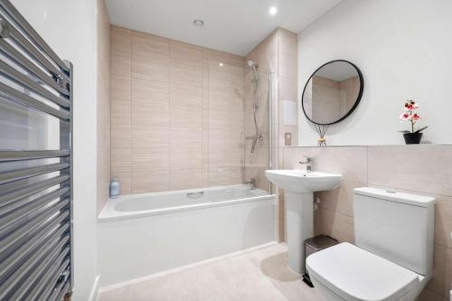 a bathroom with a toilet and a tub and a sink at Modern 2 Bedroom Flat with FREE Parking, Close to Heathrow and Thorpe Park in Staines