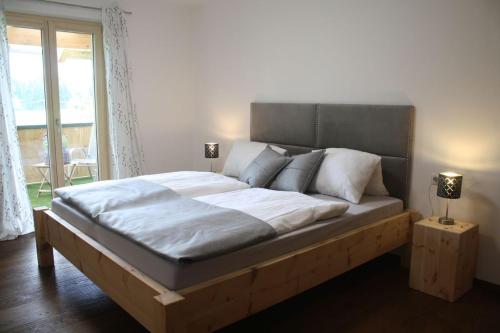 a large bed in a bedroom with a window at Sonnseite in Punschern in Teisendorf