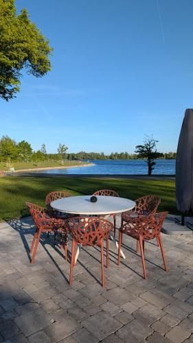 a table and chairs and a table and chairs at Ferienwohnung Coproyshof - Direkt am See - 3 Schlafzimmer, privater Strand & Feuerstelle in Wesel
