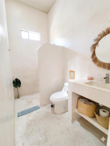 a bathroom with a toilet and a sink and a mirror at Nuik Casa Tropical in Mérida