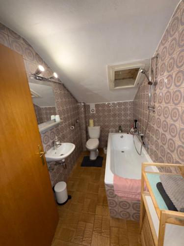 a bathroom with a tub and a sink and a toilet at Haus Waldfrieden in Sautens