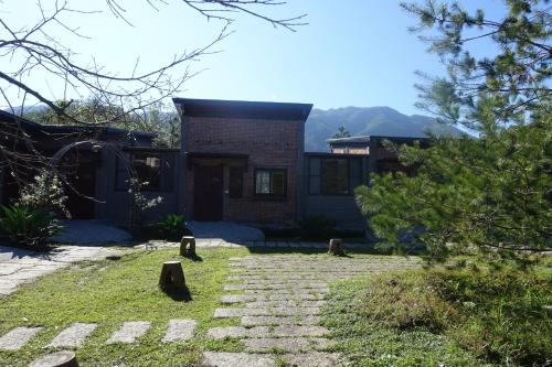 a house with a stone pathway in front of it at Old House Homestay in Sanxing