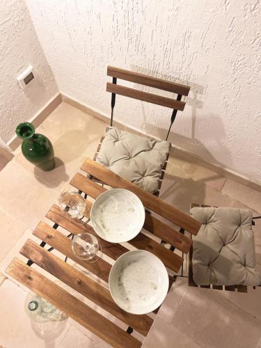 a wooden bench with two tables and a chair at Civico 39 in Ostuni