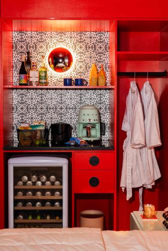 a small kitchen with red cabinets and a stove at Hotel Hilo - Room 104 in Louisville