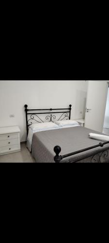 a bedroom with a bed with a black metal frame at Casa vacanza Lea in Veglie