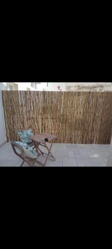 a picnic table and a chair in front of a fence at Casa vacanza Lea in Veglie