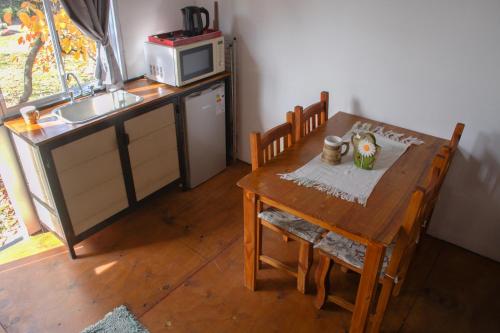 a kitchen with a wooden table and a table and a microwave at La Moderna in La Falda