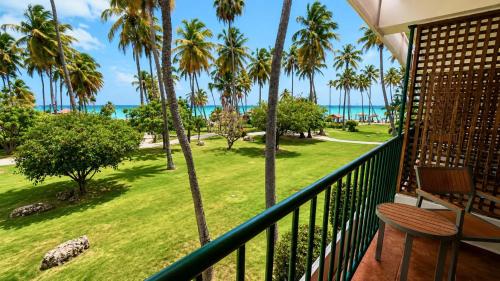 a balcony with a view of the beach and palm trees at Copamarina Beach Resort & Spa in Guanica