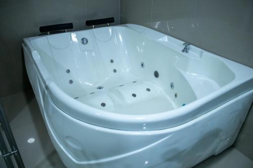 a white bath tub sitting in a bathroom at Hotel Perla Azul Girardot in Girardot