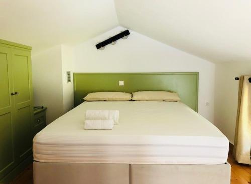 a bedroom with a large bed with two towels on it at Vrakades - Guest House in Kouniádhoi