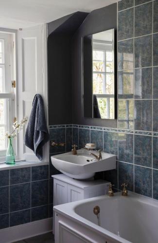a bathroom with a sink and a tub and a mirror at Newbyth Garden Cottage in East Linton