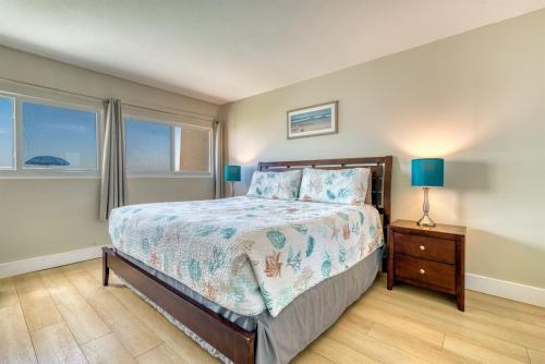 a bedroom with a bed and a nightstand and two lamps at Beach House Condominiums C103 - Beachfront with Pool, Wi-Fi, & Beach Service in Destin