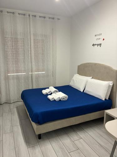 a bedroom with a blue bed with towels on it at Cavallerizza home in Naples