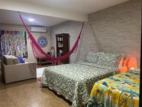 a bedroom with a bed and a hammock in it at Espaço Aconchego in Pomerode