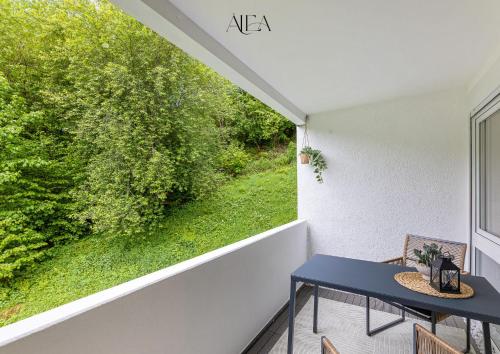 a balcony with a blue table and a large window at ALEA-Apartment - Bad Wildbad in Bad Wildbad