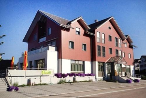 a large building with purple flowers in front of it at Hotel Garni Bären Bazenheid in Bazenheid