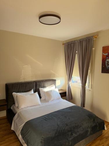 a bedroom with a large bed and a window at Apartment N6 Shkoder in Shkodër