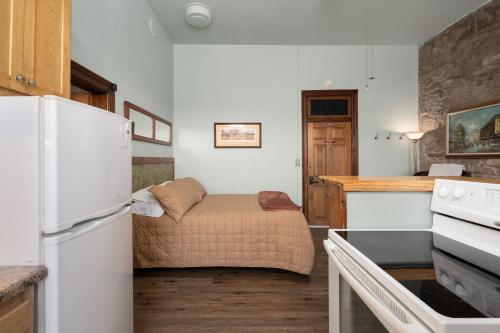 a small kitchen with a bed and a refrigerator at Del Norte Colorado Stone Quarry Studio Apt in Del Norte