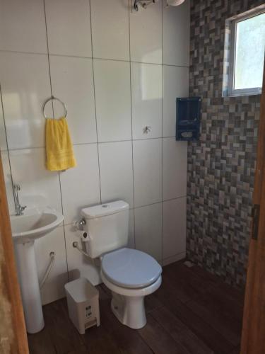 a bathroom with a toilet and a sink at Siio do bambu in Joinville