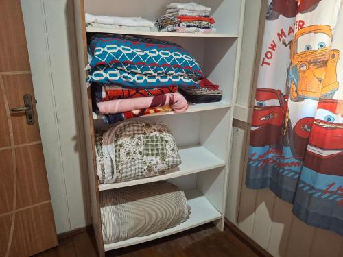 a closet with white shelves and a crib at Siio do bambu in Joinville