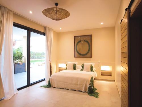 a bedroom with a bed and a large window at Villa Tarrafal in Somone