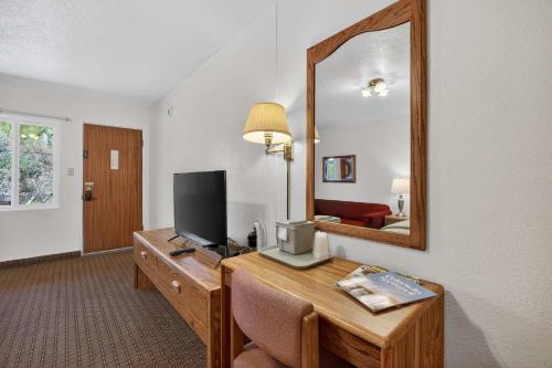 a room with a desk with a television and a mirror at Eagle Motel Suite 107 in Manitou Springs