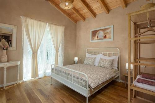 a bedroom with a white bed and a window at Villa Stonica in Kringa