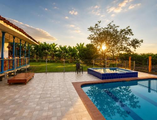 a patio with a swimming pool and a house at Finca Hotel Estrella del Eden in Armenia